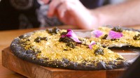 Pizza dengan adonan hitam yang pipih ini dipenuhi dengan taburan emas di bagian atasnya. Topping foie gras hingga truffle juga melengkapi pizza seharga Rp 32,5 juta. Foto: Istimewa