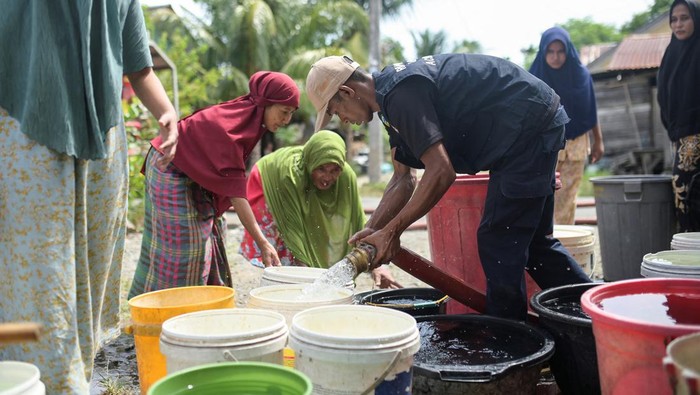 Warga Desa di Aceh Besar Kesulitan Air Bersih Saat Kemarau Acehnese women queue for clean water distributed by the regional disaster agency during a drought in Lambaro Seubun Village, Lhoknga, Aceh Besar, Indonesia, July 31, 2024. REUTERS/Riska Munawarah