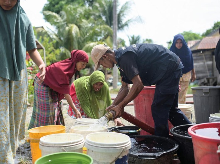 Acehnese women queue for clean water distributed by the regional disaster agency during a drought in Lambaro Seubun Village, Lhoknga, Aceh Besar, Indonesia, July 31, 2024. REUTERS/Riska Munawarah