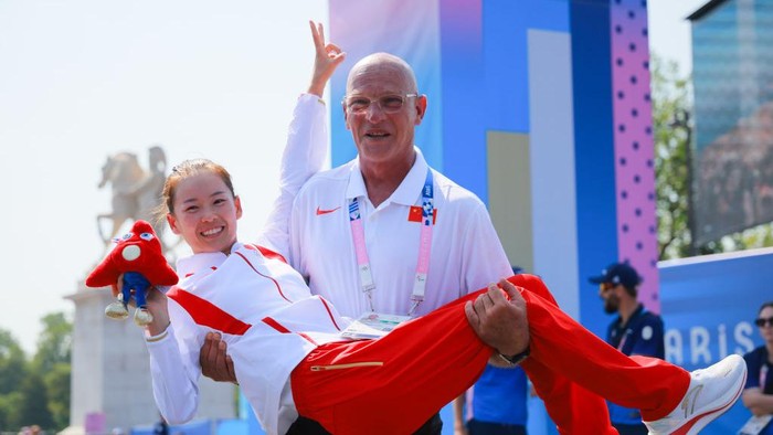 PARIS, FRANCE - AUGUST 01: Coach Patrizio Antonio Parcesepe lifts up gold medalist Chinas Yang Jiayu during the medal ceremony after the Athletics - Womens 20km Race Walk on day six of the Paris 2024 Olympic Games at Trocadero on August 1, 2024 in Paris, France. (Photo by Lu Lin/CHINASPORTS/VCG via Getty Images)