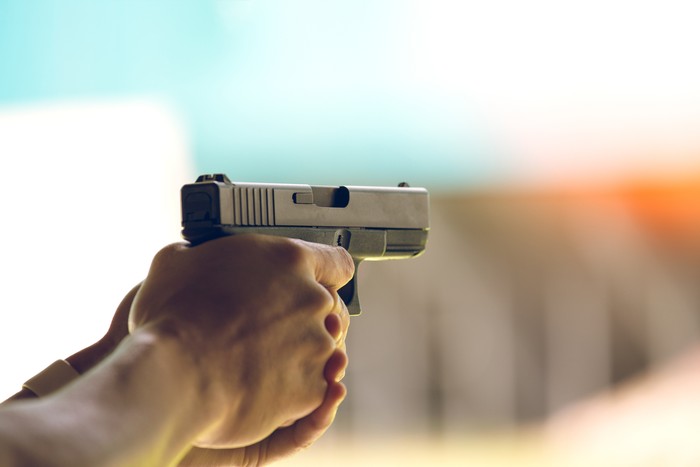 hand aim pistol in academy shooting range with flare and vintage color