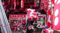 Pekerja memanggul umbul-umbul yang telah dikemas di Kampung Bendera di Jalan Darmokali, Surabaya, Jawa Timur, Jumat (2/8/2024).