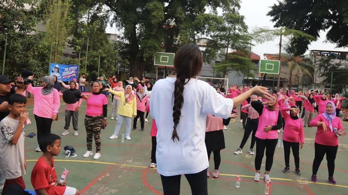 Sejumlah emak-emak melakukan olahraga pilates di Jatinegara, Jakarta. Mereka kompak memakai baju berwarna pink.