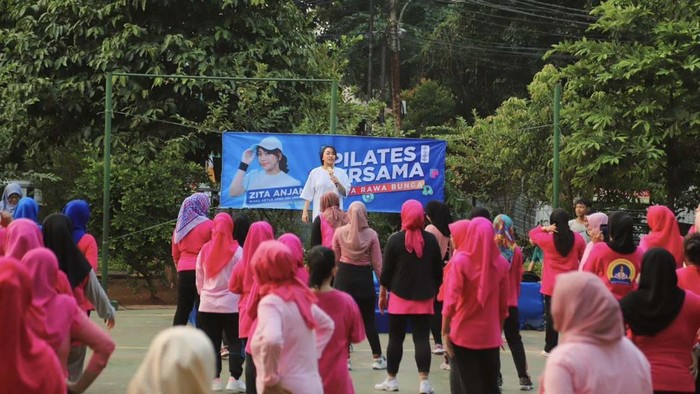 Sejumlah emak-emak melakukan olahraga pilates di Jatinegara, Jakarta. Mereka kompak memakai baju berwarna pink.