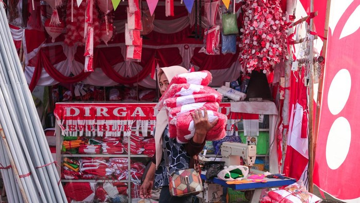 Pekerja memanggul umbul-umbul yang telah dikemas di Kampung Bendera di Jalan Darmokali, Surabaya, Jawa Timur, Jumat (2/8/2024). Kampung Bendera merupakan salah satu lokasi penjualan bendera Merah Putih, umbul-umbul dan berbagai aksesoris lainnya di Surabaya yang bisa dibeli oleh masyarakat menjelang HUT ke-79 Kemerdekaan RI. ANTARA FOTO/Didik Suhartono/foc.