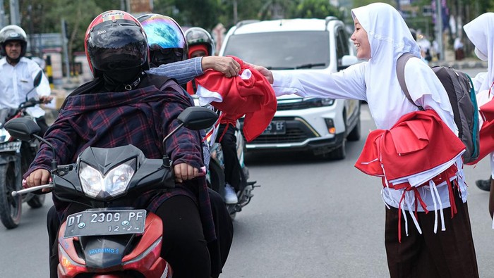 Pelajar Bagi-bagi Bendera Merah Putih di Kendari Sejumlah siswa membentangkan bendera merah putih saat pembagian bendera kepada masyarakat yang melintas di Jalan Supu Yusuf, Kendari, Sulawesi Tenggara, Jumat (2/8/2024). Dinas Pendidikan dan Kebudayaan Sulawesi Tenggara membagikan sebanyak 17.000 bendera Merah Putih kepada warga dalam rangka menyambut HUT ke-79 Kemerdekaan RI. ANTARA FOTO/Andry Denisah/Spt.