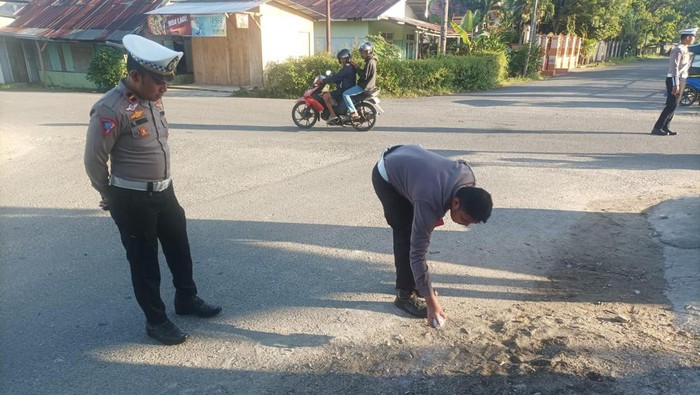 Polisi melakukan olah TKP di lokasi anggota polisi tertabrak mobil Damkar Bone Bolango.