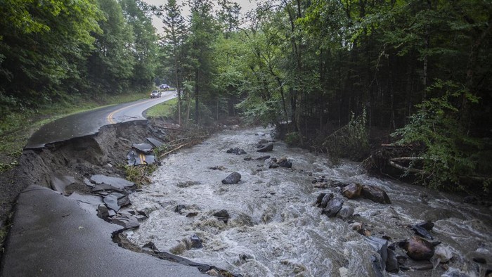 A river flows past a damaged road in the aftermath of flash floods in Lyndonville, Vt., Wednesday, July 31, 2024. (AP Photo/Dmitry Belyakov)