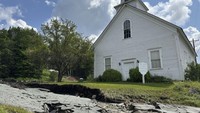 Jalan rusak akibat banjir terlihat di depan sebuah rumah di Morgan, Vermont, AS, Kamis (1/8/2024). AP Photo/Lisa Rathke