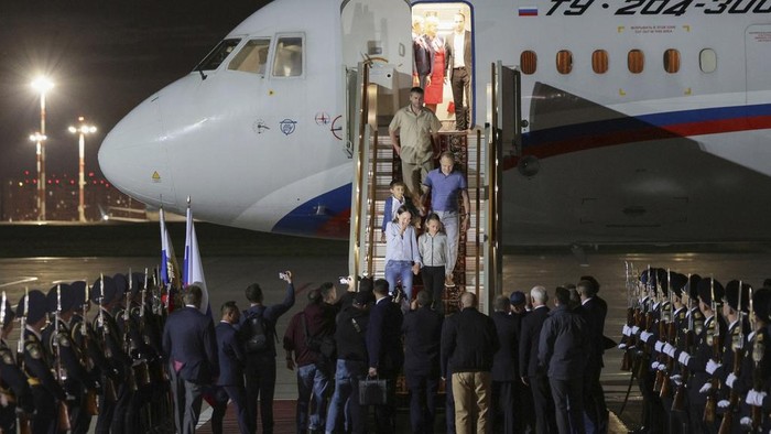 Russian President Vladimir Putin, center back to a camera, greets released Russian prisoners upon their arrival at the Vnukovo government airport outside Moscow, Russia, on Thursday, Aug. 1, 2024. The United States and Russia have made their biggest prisoner swap in post-Soviet history. (Gavriil Grigorov/Sputnik, Kremlin Pool Photo via AP)