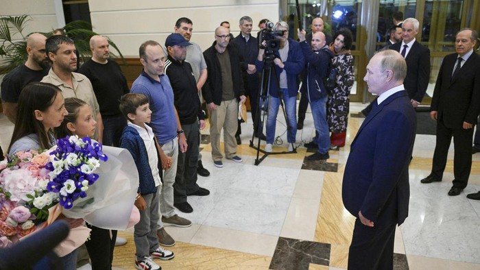 Russian President Vladimir Putin, foreground right, walks with released Russian prisoners upon their arrival at the Vnukovo government airport outside Moscow, Russia, on Thursday, Aug. 1, 2024. (Kirill Zykov, Sputnik, Kremlin Pool Photo via AP)