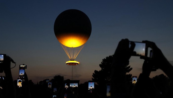 People film the nightly raising of the Olympic Cauldron from the Tuileries Garden during the Olympic Games in Paris, France, July 29, 2024. REUTERS/Kevin Coombs