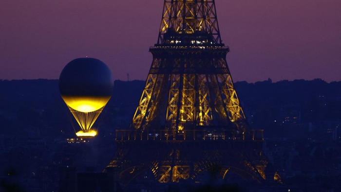 Saat Kaldron Olimpiade Terangi Langit Malam Paris Paris 2024 Olympics - Paris, France - July 28, 2024 The Olympic cauldron and the Eiffel Tower after sunset during the Olympics REUTERS/Christian Hartmann