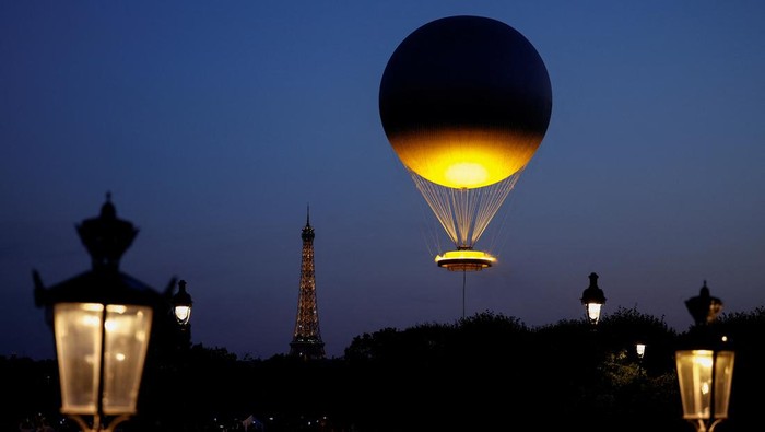 The Paris 2024 Olympic Games cauldron attached to a balloon floats with the Eiffel Tower in the background, in Paris, France, July 29, 2024. REUTERS/Benoit Tessier