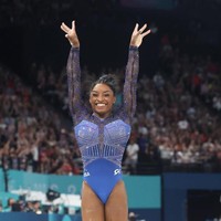 Simon Biles, yang menjadi kapten tim senam AS, tak kalah tampil berkilauan. Peraih delapan medali emas Olimpiade ini tampil dengan leotard bernuansa midnight blue. Foto: Getty Images