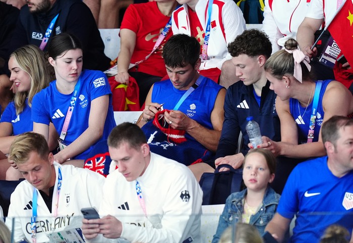 Great Britains Tom Daley knitting as he watches the Womens Synchronised 3m Springboard Final at the Aquatics Centre on the first day of the 2024 Paris Olympic Games in France. Picture date: Saturday July 27, 2024. (Photo by Mike Egerton/PA Images via Getty Images)