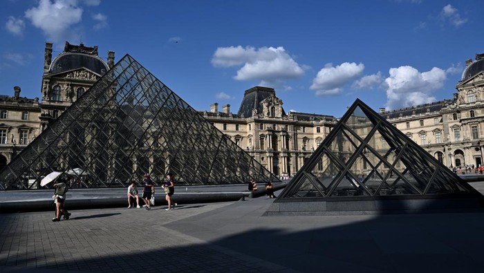 Pengunjung melintasi Piramida Louvre yang diarsiteki I M Pei di Museum Louvre, Paris, Prancis, Jumat (2/8/2024). Museum Louvre pernah dinobatkan dengan predikat “world’s most visited art museum” pada 2018 karena dikunjungi lebih dari sepuluh juta orang. ANTARA FOTO/Wahyu Putro A/foc.