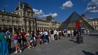 Pengunjung antre berfoto di cincin olimpiade dengan latar belakang Piramida Louvre yang diarsiteki I M Pei di Museum Louvre, Paris, Prancis, Jumat (2/8/2024). Musee de Louvre dikunjungi lebih dari 10 juta wisatawan tiap tahunnya, hampir setara kunjungan wisman ke Indonesia dalam 1 tahun. Inilah museum yang paling banyak dikunjungi di dunia.