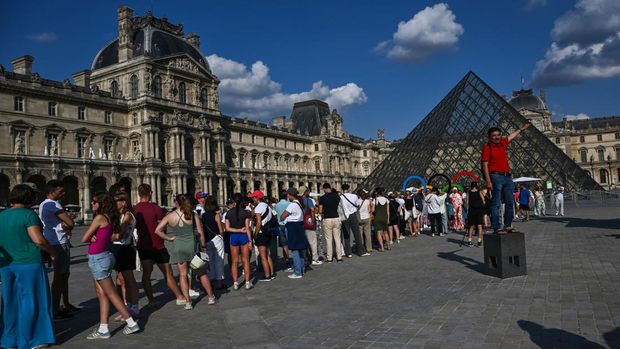 Pengunjung melintasi Piramida Louvre yang diarsiteki I M Pei di Museum Louvre, Paris, Prancis, Jumat (2/8/2024). Museum Louvre pernah dinobatkan dengan predikat 