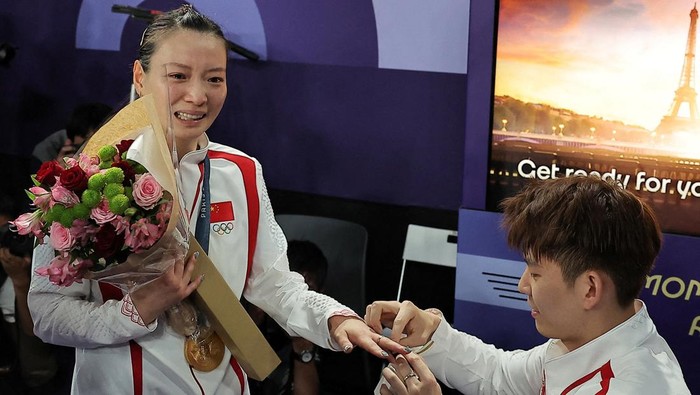 Paris 2024 Olympics - Badminton - Mixed Doubles Victory Ceremony - Porte de La Chapelle Arena, Paris, France - August 02, 2024. Liu Yuchen of China proposes to teammate Ya Qiong Huang of China after she won the gold.  REUTERS/Ann Wang  REFILE - CORRECTING ID FROM 