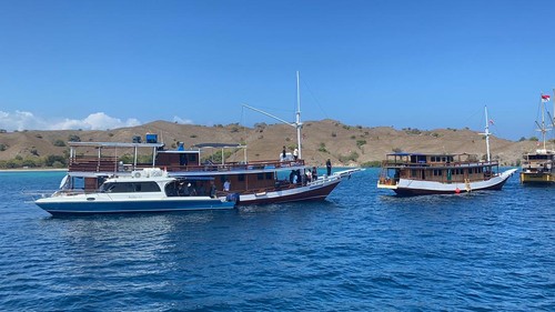 Kapal Pinisi Dirga Kabila (di belakang speedboat) terjaring operasi Pemkab Manggarai Barat bersama KPK di perairan Pink Beach Pulau Komodo, Sabtu (3/8/2024) (Foto: Istimewa)