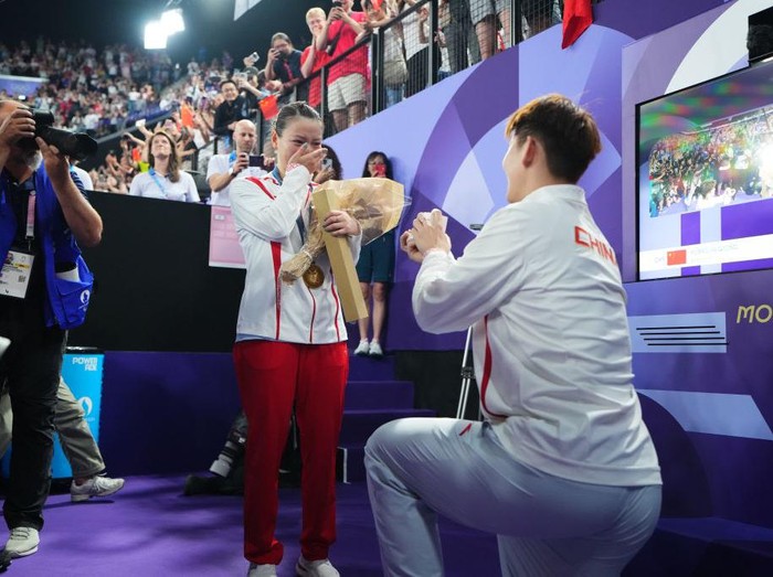 Pebulutangkis Liu Yuchen melamar peraih medali emas Huang Yaqiong usai upacara perebutan medali emas Ganda Campuran pada hari ketujuh Olimpiade Paris 2024 di Porte de La Chapelle Arena pada 2 Agustus 2024 di Paris, Prancis.