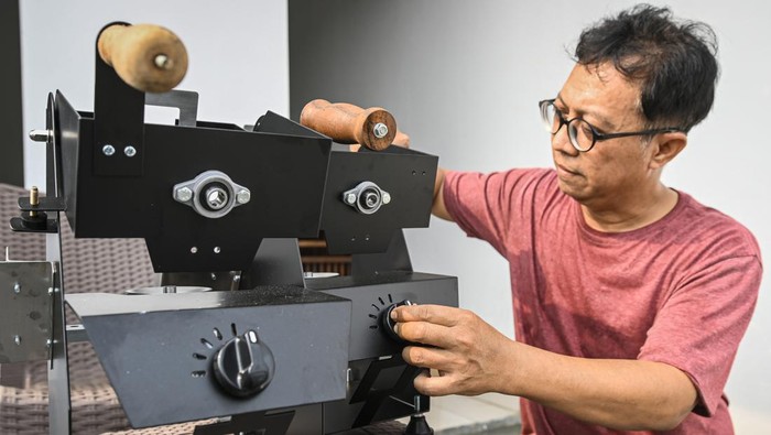 Perajin memasukkan biji kopi ke dalam mesin sangrai (roaster) di bengkel Minicaff Coffe Roaster, Kota Tangerang, Banten, Jumat (2/8/2024).  Mesin penyangrai biji kopi berbahan dasar baja nirkarat tersebut dijual seharga Rp2,6 juta hingga Rp4,9 juta tergantung ukuran dan fitur yang diperuntukkan bagi pengguna rumahan dan terjual sampai ke Malaysia dan Oman. ANTARA FOTO/Sulthony Hasanuddin/rwa.