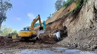 Tebing setinggi 25 meter ini longsor menimpa truk bermuatan pasir yang sedang melintas.