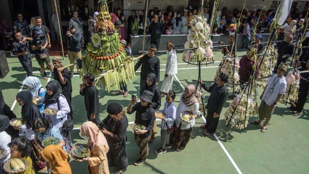 Masyarakat adat membawa olahan hasil bumi saat tradisi tradisi Tutup Taun (Tahun) 1957 dan Ngemban Taun 1 Sura 1958 di Kampung Adat Cireundeu, Cimahi, Jawa Barat, Sabtu (3/8/2024). Tradisi dan seni budaya yang digelar oleh masyarakat adat yang terkenal dengan mengonsumsi olahan singkong menjadi beras (rasi) tersebut sebagai bentuk pengungkapan rasa syukur atas nikmat kehidupan dan alam yang telah diberikan oleh Sang Pencipta selama setahun sekaligus prosesi dalam menjaga warisan budaya. ANTARA FOTO/Novrian Arbi/foc.