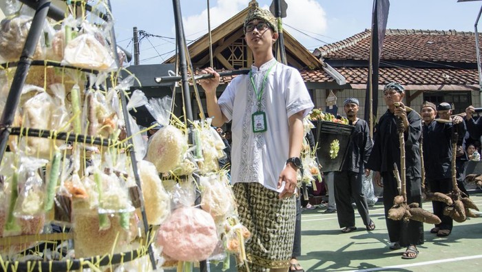 Tradisi Tutup Taun Kampung Adat Cireundeu Masyarakat adat membawa olahan hasil bumi saat tradisi tradisi Tutup Taun (Tahun) 1957 dan Ngemban Taun 1 Sura 1958 di Kampung Adat Cireundeu, Cimahi, Jawa Barat, Sabtu (3/8/2024). Tradisi dan seni budaya yang digelar oleh masyarakat adat yang terkenal dengan mengonsumsi olahan singkong menjadi beras (rasi) tersebut sebagai bentuk pengungkapan rasa syukur atas nikmat kehidupan dan alam yang telah diberikan oleh Sang Pencipta selama setahun sekaligus prosesi dalam menjaga warisan budaya. ANTARA FOTO/Novrian Arbi/foc.
