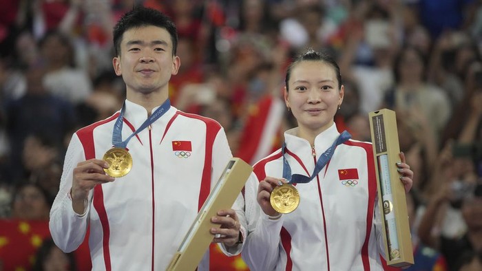 Chinas Zheng Si Wei, left, and Huang Ya Qiong hold their gold medals during the medal ceremony for the mixed doubles badminton finals at the 2024 Summer Olympics, Friday, Aug. 2, 2024, in Paris, France. (AP Photo/Dita Alangkara)
