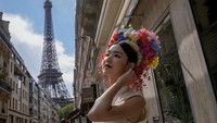 Hu Xiao, dari Tiongkok, berpose saat teman-temannya mengambil fotonya di dekat Menara Eiffel. AP/Dar Yasin