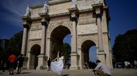 Turis berfoto di dekat Arc de Triomphe du Carrousel pada Olimpiade Musim Panas 2024. AP/Natacha Pisarenko