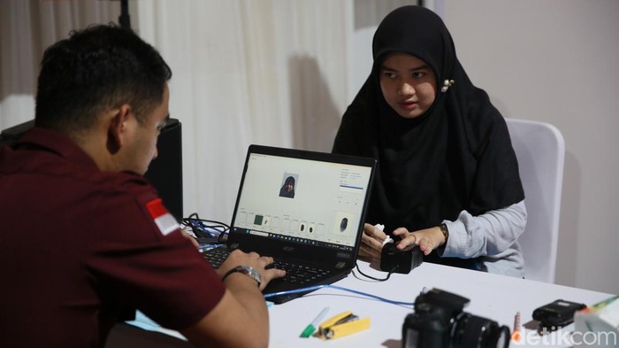 Sejumlah petugas Imigrasi merekam data pemohon pembuatan paspor saat Layanan Publik Kemenkumham di Plaza Sudirman, kawasan GBK, Senayan, Jakarta, Minggu (4/8/2024). Kegiatan tersebut dalam rangka Hari Pengayoman ke-79 Kementerian Hukum dan HAM.