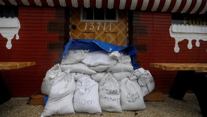 Antisipasi Badai, Warga Florida Lindungi Toko dengan Papan-Karung Pasir The Candy Kitchen is closed with sandbags placed in front of the entrance, while Tropical Storm Debby approaches the gulf coast in Madeira Beach, Florida, U.S., August 4, 2024. REUTERS/Octavio Jones