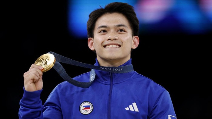 Paris 2024 Olympics - Artistic Gymnastics - Mens Vault Victory Ceremony - Bercy Arena, Paris, France - August 04, 2024. Gold medallist Carlos Edriel Yulo of Philippines celebrates with his medal on the podium. REUTERS/Amanda Perobelli