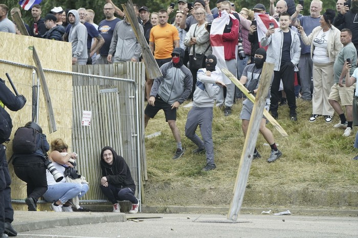 A chair is thrown at police officers as trouble flares during an anti-immigration protest outside the Holiday Inn Express in Rotherham, England, Sunday Aug. 4, 2024. (Danny Lawson/PA via AP)