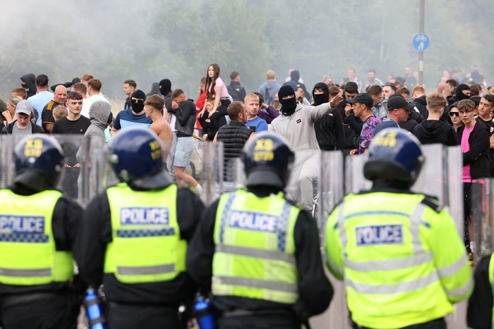 Demonstrators toss a trash bin during an anti-immigration protest, in Rotherham, Britain, August 4, 2024. REUTERS/Hollie Adams