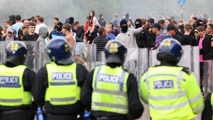 Demonstrators toss a trash bin during an anti-immigration protest, in Rotherham, Britain, August 4, 2024. REUTERS/Hollie Adams