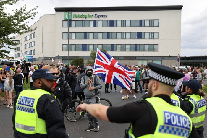 Demonstrators toss a trash bin during an anti-immigration protest, in Rotherham, Britain, August 4, 2024. REUTERS/Hollie Adams