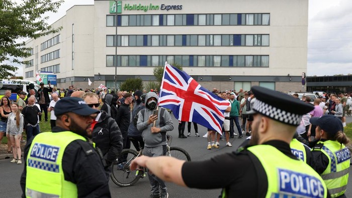 Inggris Memanas, Demo Anti-Imigran Berujung Ricuh Demonstrators toss a trash bin during an anti-immigration protest, in Rotherham, Britain, August 4, 2024. REUTERS/Hollie Adams