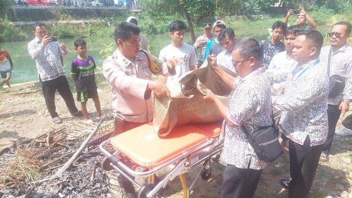 Jenazah mayat bocah laki-laki yang ditemukan mengambang di sungai saat dievakuasi. (dok. Polresta Padang)