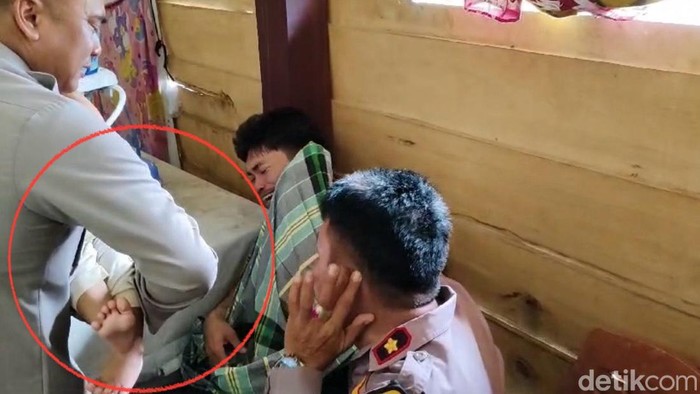 Kapolres Pinrang, AKBP Andiko Wicaksono menggendong bayi yang sebelumnya disandera dan diancam dibunuh oleh ayahnya.