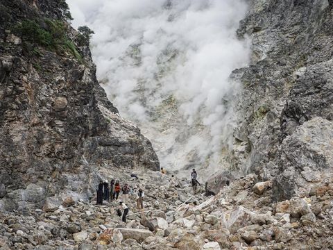 Pengunjung melihat asap dan belerang yang keluar dari dinding kawah Candradimuka di Gunung Lawu, Tawangmangu, Karanganyar, Jawa Tengah, Senin (5/8/2024). Kawah yang berada di jalur pendakian Cemara Kandang dengan ketinggian sekitar 2.550 mdpl tersebut menjadi lokasi favorit pendaki untuk singgah sekaligus melihat aktifitas vulkanik Gunung Lawu. ANTARA FOTO/Mohammad Ayudha/nz.