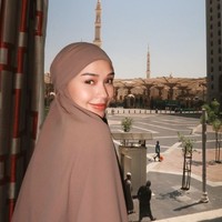 Dalam foto ini, Lula memilih French khimar berwarna cokelat bahan crinkle yang jatuh (flowy) selama di Tanah Suci. Pesinetron High School Love Story ini menggunakan riasan wajah natural look yang memberikan kesan segar dan bercahaya. Foto: Instagram/lulalahfah.