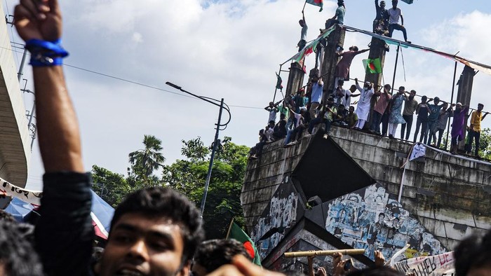 Ribuan Warga Bangladesh Turun ke Jalan Rayakan Mundurnya PM Sheikh Hasina Protesters climb a public monument as they celebrate after getting the news of Prime Minister Sheikh Hasina's resignation, in Dhaka, Bangladesh, Monday, Aug. 5, 2024. (AP Photo/Rajib Dhar)
