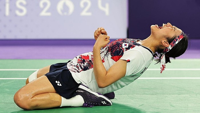 Paris 2024 Olympics - Badminton - Women's Singles Gold Medal Match - Porte de La Chapelle Arena, Paris, France - August 05, 2024. Se Young An of South Korea celebrates on the ground after winning gold in the match against Bing Jiao He of China. REUTERS/Ann Wang