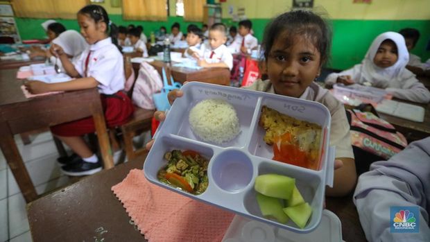 Siswa-siwi menyantap hidangan makan bergizi saat uji coba program makam bergizi gratis di SDN 4 Tangerang, Banten, Senin (5/8/2024). Makan bergizi gratis merupakan program unggulan yang dibawa Prabowo-Gibran saat kampanye di Pilpres 2024 lalu dan tetap berpegang kepada anggaran yang tersedia pada RAPBN 2025 sebesar Rp71 triliun. (CNBC Indonesia/Faisal Rahman)