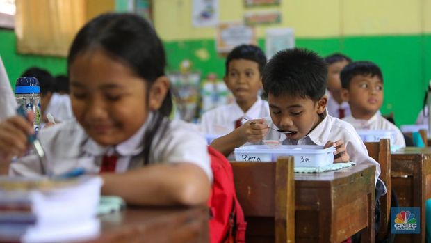 Siswa-siwi menyantap hidangan makan bergizi saat uji coba program makam bergizi gratis di SDN 4 Tangerang, Banten, Senin (5/8/2024). Makan bergizi gratis merupakan program unggulan yang dibawa Prabowo-Gibran saat kampanye di Pilpres 2024 lalu dan tetap berpegang kepada anggaran yang tersedia pada RAPBN 2025 sebesar Rp71 triliun. (CNBC Indonesia/Faisal Rahman)