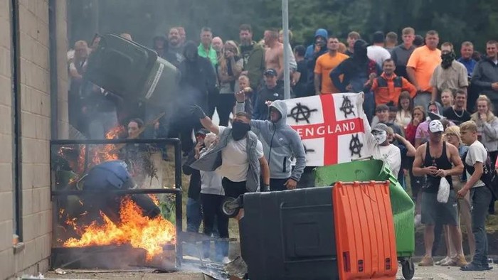 Demonstrators toss a trash bin during an anti-immigration protest, in Rotherham, Britain, August 4, 2024. (Reuters)